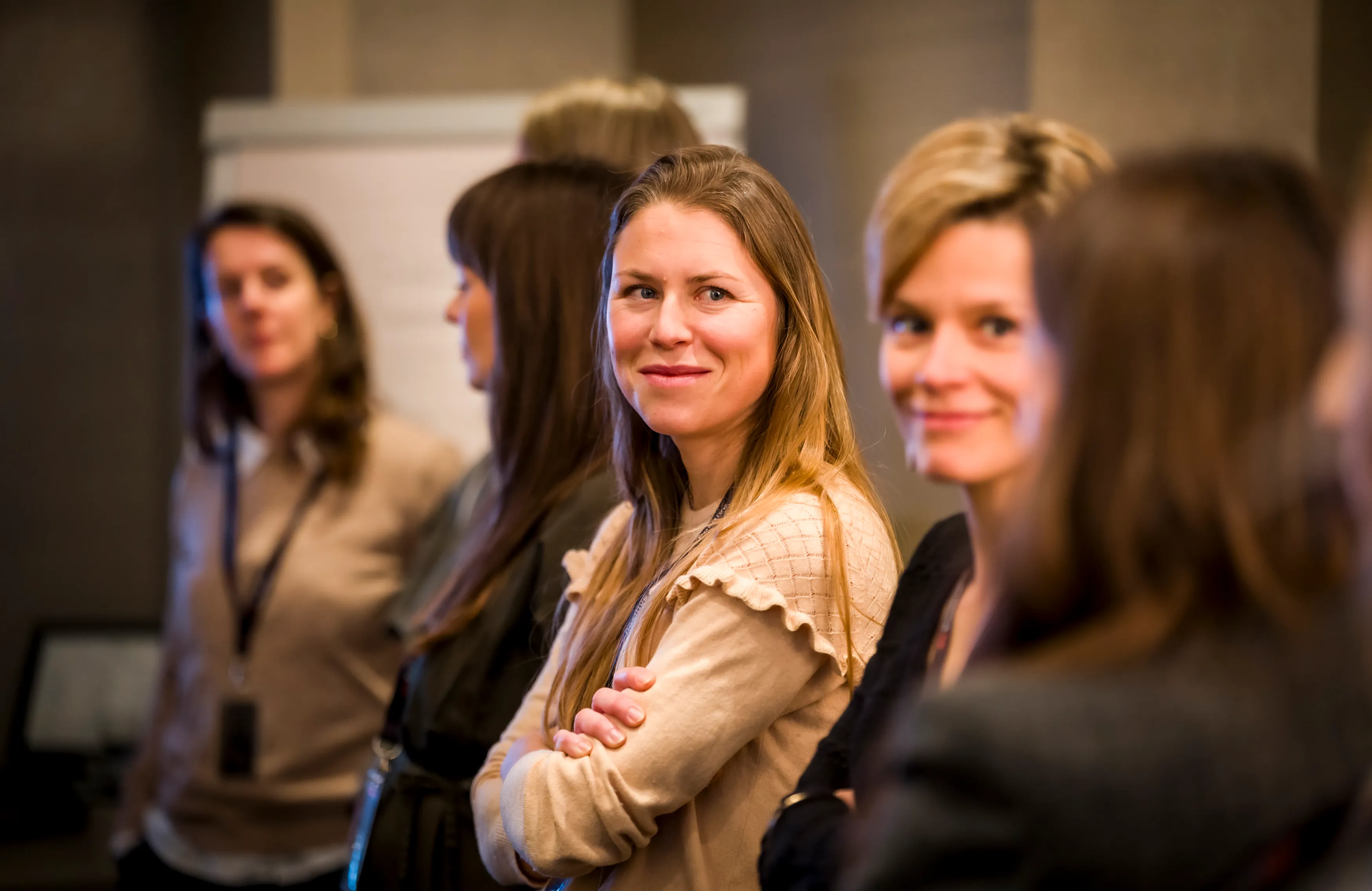Smiling female employees from Positive group during an internal training session.